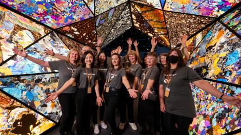Western Australian Museum volunteers pose for a group photo underneath the Museum's colourful mineral archway